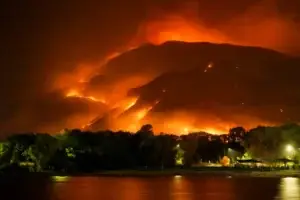 Wildfire burning on an East Bay hillside above a residential neighborhood at night
